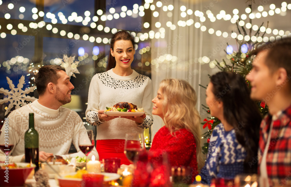 holidays and celebration concept - happy friends having christmas dinner at home