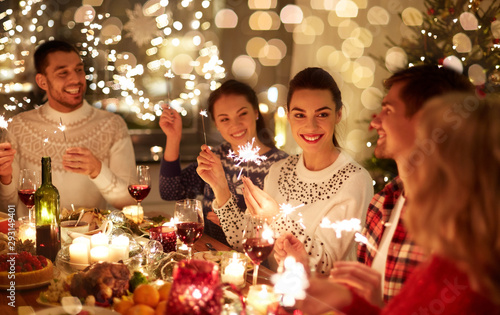 Photo winter holidays and people concept - happy friends with sparklers celebrating ch