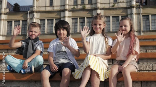 Children smiling and waving hands looking at camera. photo