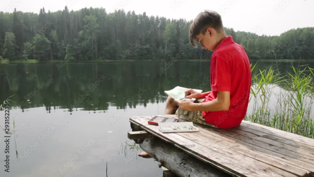 Teen boy sketching summer landscape with pastel sticks Teen boy sketching summer landscape with pastel sticks