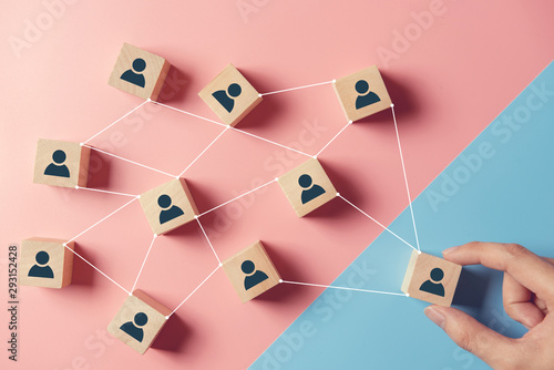 Building a strong team, Wooden blocks with people icon on blue and pink background, Human resources and management concept.