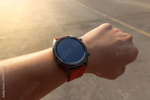 Smart watch circle type on wrist for exercise while having orange light