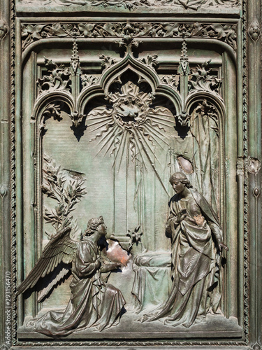 Ornate detail of the bronze door of Milan Catehdral in Italy photo