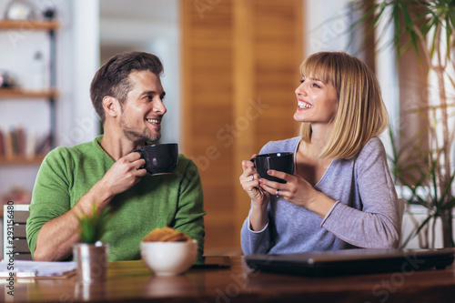 Couple talking in the night in the living room at home and drink tea
