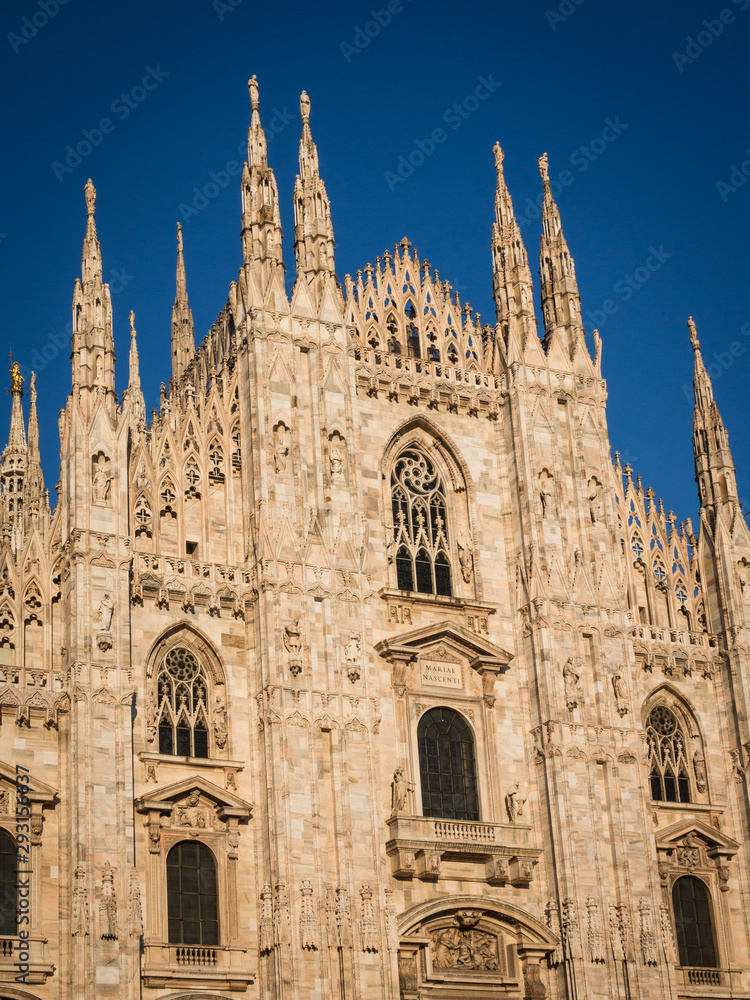 Ornate facade of Milan Catehdral in Italy at sunset