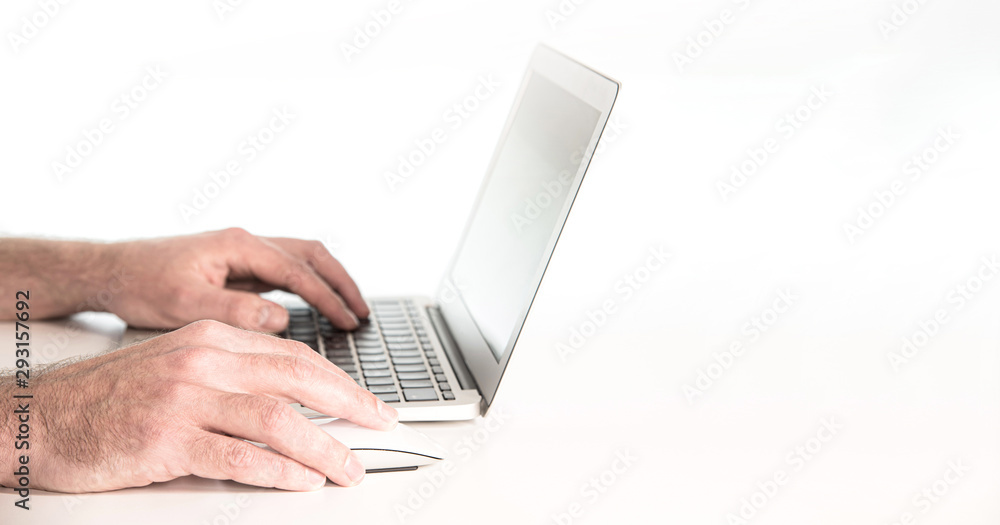 close-up of hands of person using laptop computer and wireless mouse against white background close-up of hands of person using laptop computer and wireless mouse against white background