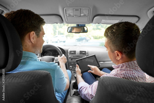 driver courses and people concept - man and driving school instructor with tablet computer in car © Syda Productions