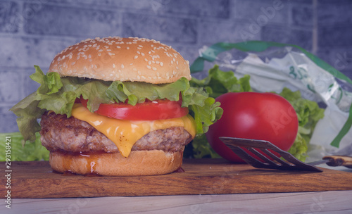 Hamburger or sandwich. Delicious sandwich hamburger with meat, cheese and fresh vegetable. Hamburger or sandwich is the popular fast food for brunch or lunch. Juicy cheeseburger