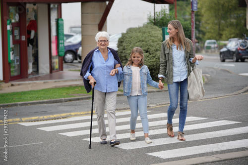Canvas Print Grandmother, mother and daughter crossing the street