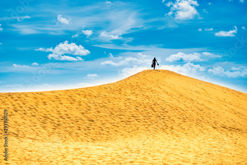 Sandy landscape with silhouette woman on top of dune. Natural reserve Maspalomas Dunes  Gran Canaria  Spain