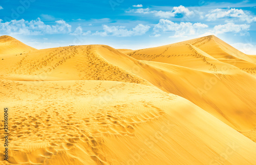 Desert with sand dunes and clouds on blue sky. Landscape of natural reserve Maspalomas Dunes. Gran Canaria, Spain