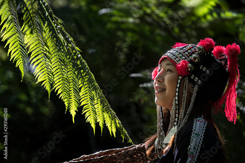 Hmong girl her have tooth braces and standing in the forest with a beautiful light in the morning in the spring. Portrait of beautiful asian lady Akha tribe or Hmong tribe in Chiang mai, Thailand.