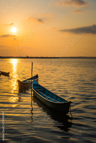 Small Fishing Boat Near Shoreline At Sunset