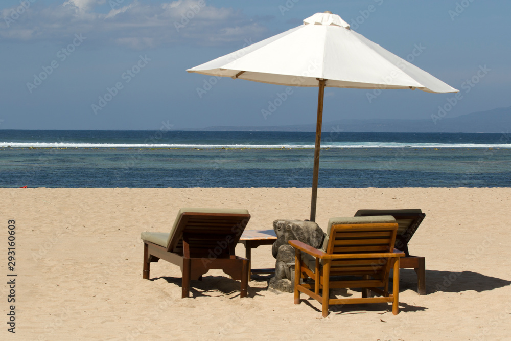 Parasol with chairs on the tropical beach of Sanur on Bali