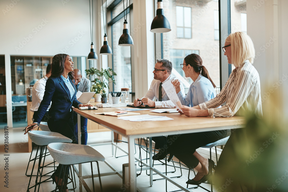 Smiling group of diverse businesspeople talking together around Smiling group of diverse businesspeople talking together around