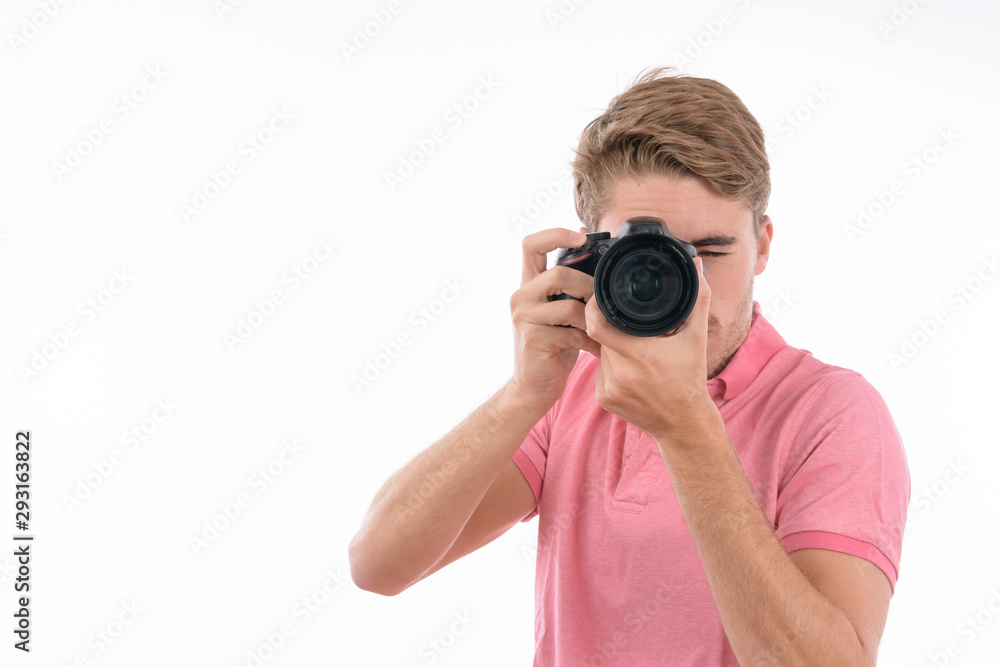 Young Caucasian man taking pictures with photo camera on isolated white background Young Caucasian man taking pictures with photo camera on isolated white background