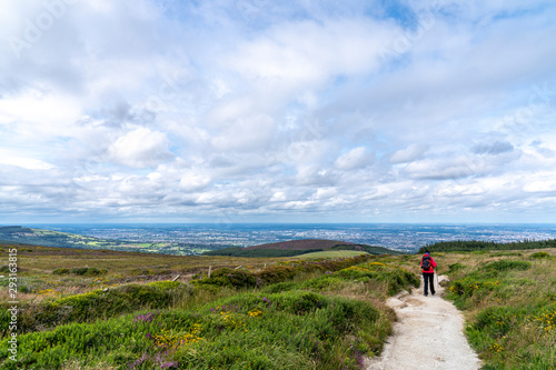 Lanscape of Wicklow way with a girl in the way and Dublin in the background.