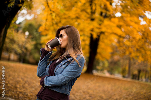 Woman drinking coffee in autumn park