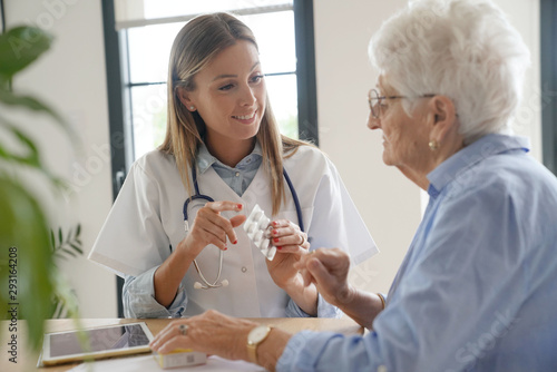Fotografija Nurse giving medication to elderly woman