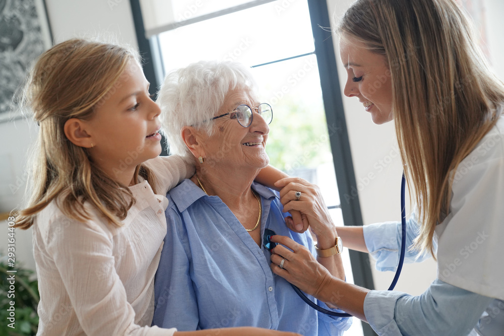 Nurse checking on elderly woman heartbeat Nurse checking on elderly woman heartbeat