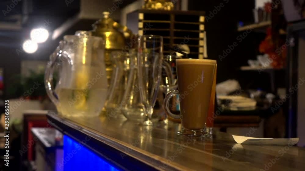 Bar counter with cocktail and crockery in a dim evening lighting at a bar Bar counter with cocktail and crockery in a dim evening lighting at a bar