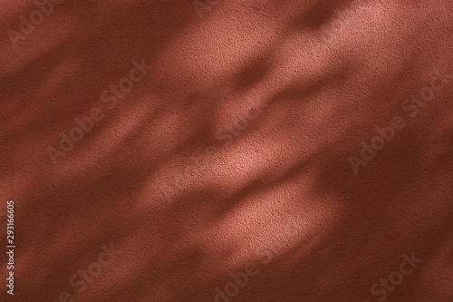 Tree shadows on brown colored wall; abstract background.