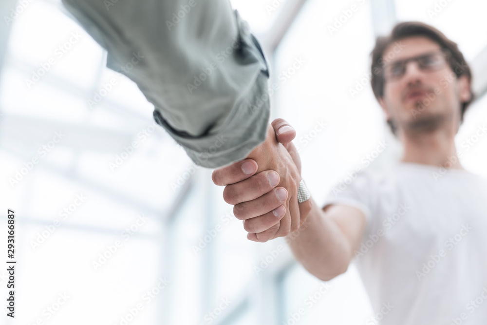 close up.young man shaking hands with his business partner close up.young man shaking hands with his business partner