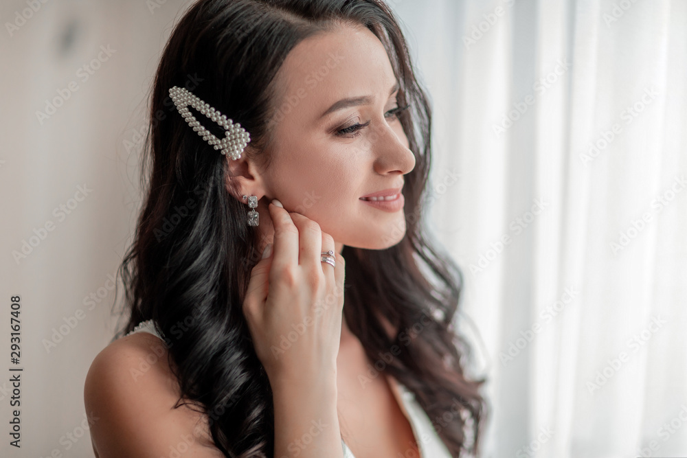 Fototapeta premium close up. girl bride trying on earrings.