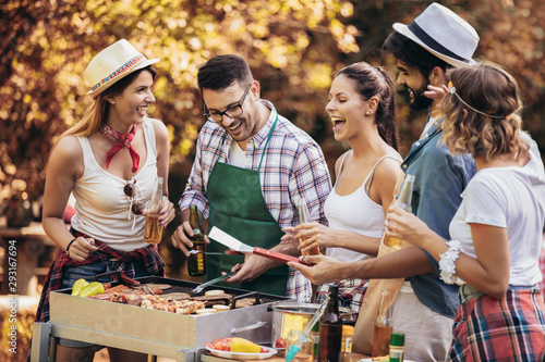 Happy friends having fun grilling meat enjoying barbecue party photo
