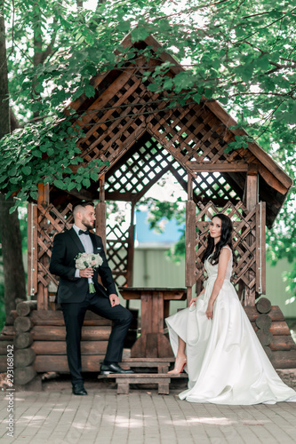 bride and groom standing near the gazebo in the Park