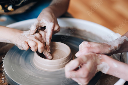 Woman potter teaching the art of pot making. 