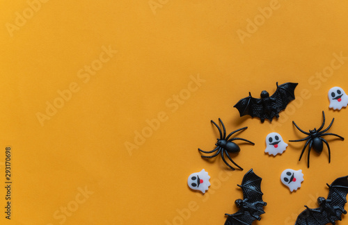 Halloween holiday concept, Spooky black spider, bats and tiny ghost in orange background with copy space for text, Top flat view wallpaper