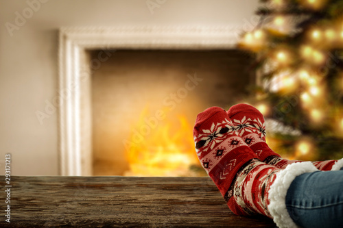 Woman legs and wool socks with fireplace 