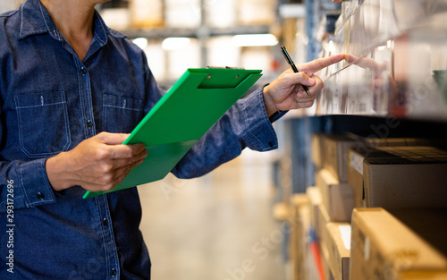 Manager man worker doing stocktaking of product management in cardboard box on shelves in warehouse. Physical inventory count.. Male professional assistant checking stock in factory.
