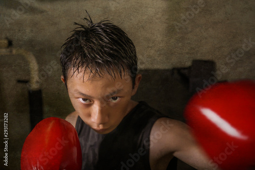 Photos tough and cool young boy punching on heavy bag