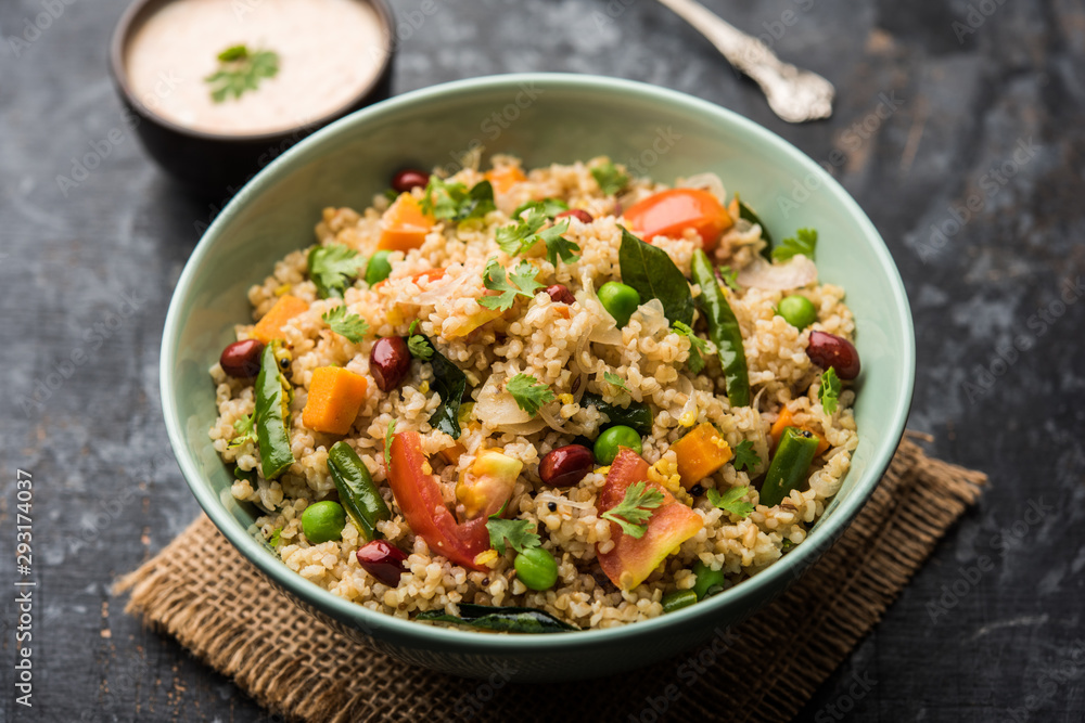 Broken wheat or Daliya Upma, served in a bowl. selective focus