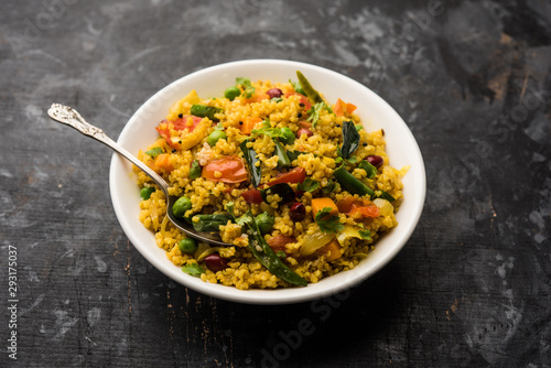 Broken wheat or Daliya Upma, served in a bowl. selective focus photo