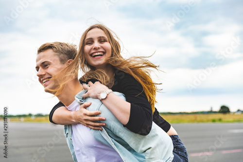 Canvas Print Happy couple having fun and enjoying a piggyback ride