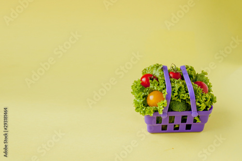 Small Fresh vegetables in basket on yellow background. Food background concept with copyspace