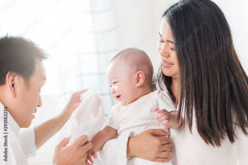 Young happy Asian mom dad and newborn baby playing at home. Young happy Asian mom dad and newborn baby playing at home.