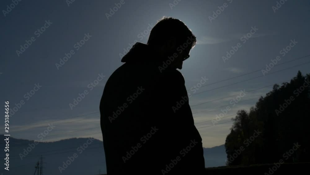 Silhouette of a man in the glare of sunlight prepares tripod Silhouette of a man in the glare of sunlight prepares tripod