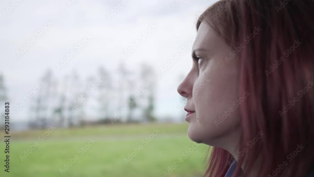 Slow motion close up shot of a thoughtful girl thinking while driving in a vehicle with motion in the background Slow motion close up shot of a thoughtful girl thinking while driving in a vehicle with motion in the background
