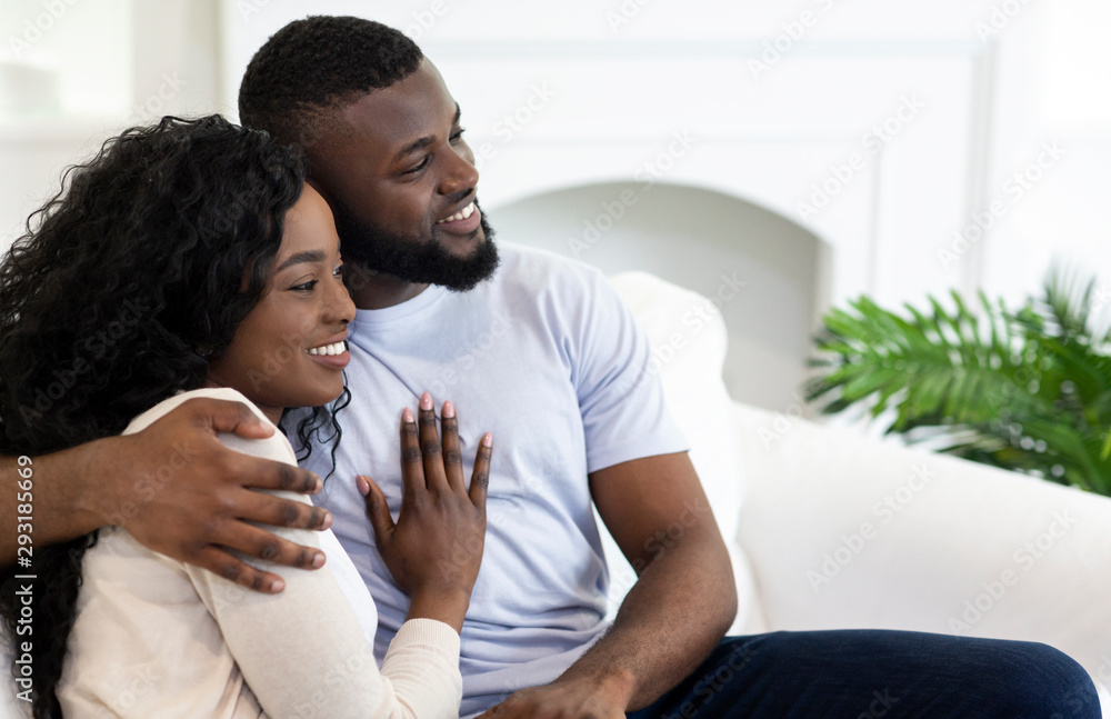 Fototapeta premium Closeup portrait of smiling africam american couple cuddling at home