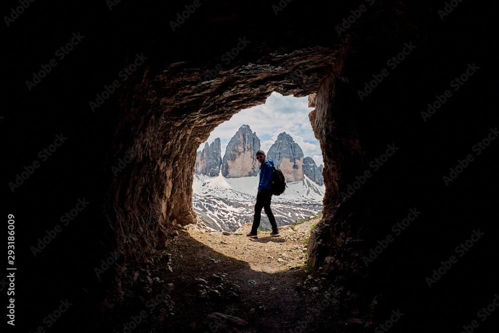 A hiker with Tre Cime di Lavaredo in the background, Dolomites, Italy