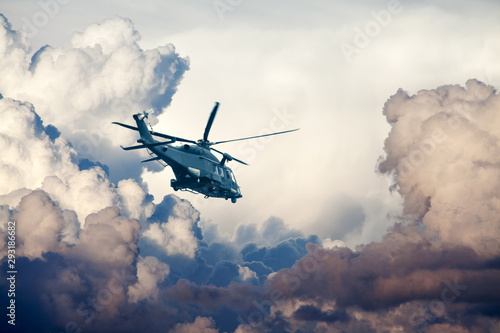 Fototapeta Wojskowy śmigłowiec AW149 latający w burzliwym niebie
