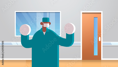 male doctor surgeon wearing surgical gloves mask and green gown medicine healthcare concept hospital medical clinic office interior portrait horizontal flat