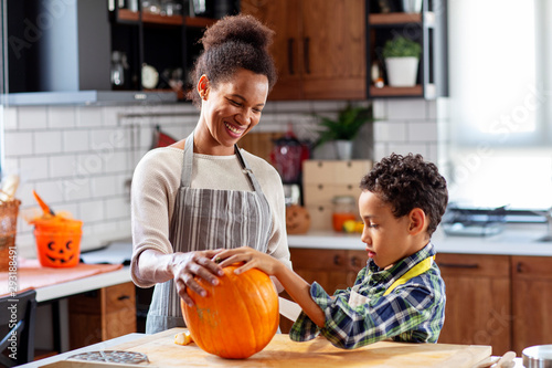 Woman with his son at the kitchen prepare pumpkin for halloween