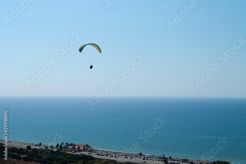 Paraglider in the sky over sea coastline