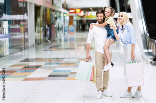 Wife Pointing Finger While Husband Carrying Daughter Shopping In Hypermarket