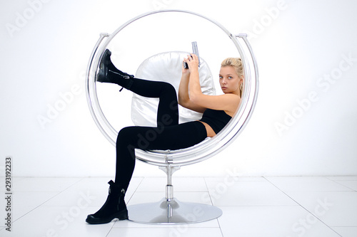 Canvas Print Blonde in a white studio with a gun